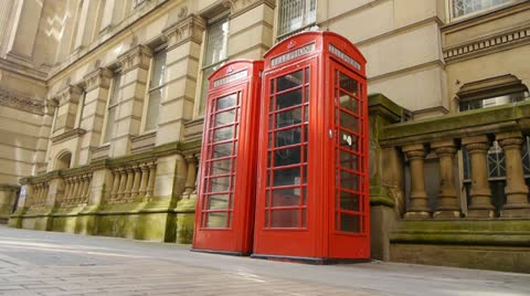 Two red english telephone boxes with a Classical architecture background