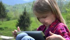4K Child Playing Tablet on Meadow Little Girl Kid Using Working … [46408445] | 写真素材・ストックフォトのアフロ