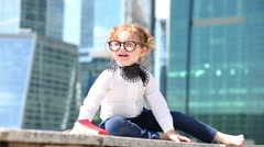 Little cute girl in glasses with red book sits on border [46536551] | 写真素材・ストックフォトのアフロ