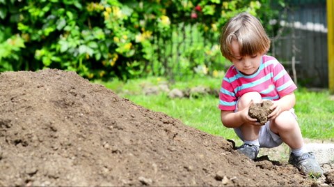 Kid playing with clay in a summer day