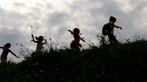 Silhouettes of children group. Kids running on hill