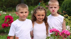 Two boys and girl in white stand among flowers and talk [46776385] | 写真素材・ストックフォトのアフロ