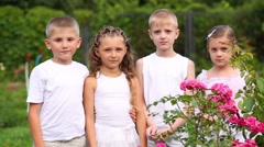 Two boys and two girls in white stand with masks among flowers [46776389] | 写真素材・ストックフォトのアフロ