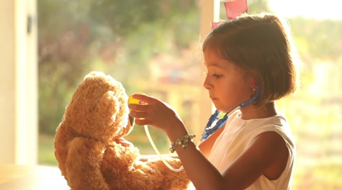 Role playing girl doctor with teddy bear