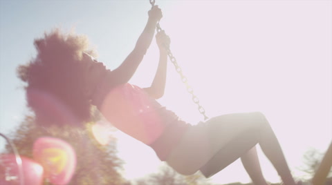 Young girl playing on a zip wire in a park