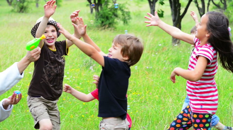 Parent playing with kids with a bubble blower