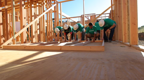 Volunteers working together lifting wall