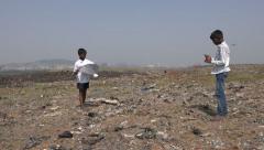 Two boys play with kites on a garbage mountain in Mumbai, India [139972505] | 写真素材・ストックフォトのアフロ