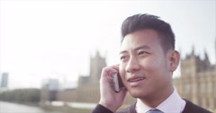 4K Young Asian businessman talking on mobile phone in London [47778831] | 写真素材・ストックフォトのアフロ