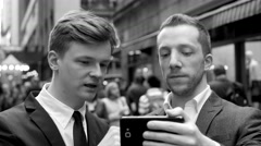 two businessman looking at smart phone watching something and … [47813865] | 写真素材・ストックフォトのアフロ