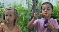 Handheld shot of two little girls blowing bubbles [47923609] | 写真素材・ストックフォトのアフロ