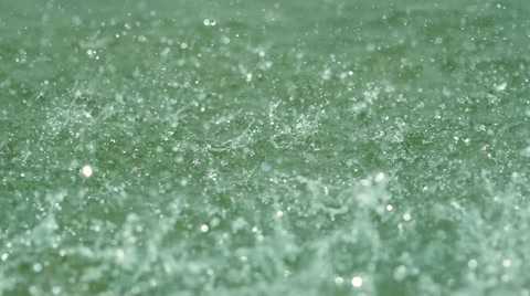 SLOW MOTION: macro shot of rain drop falling in the sea water