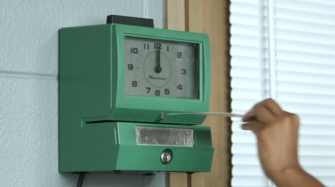 Hand putting time card in punch clock and clocking in