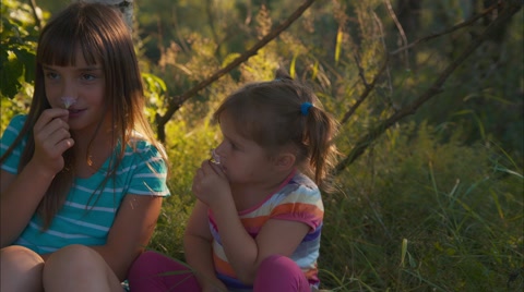 Three kids are cheerfully playing with flowers