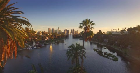 Aerial view of Echo Park Lake and downtown Los Angeles skyline at sunset. 4K UHD