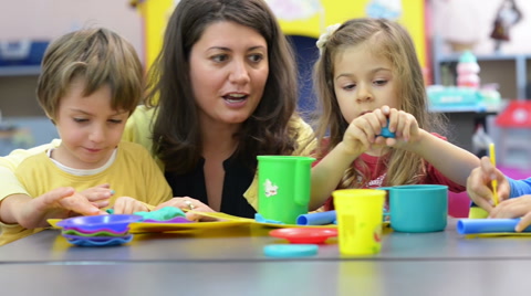 Kids playing with plasticine at kindergarten