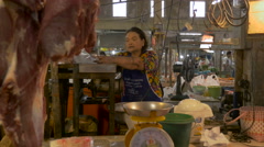 A Thai woman stuffs raw meat into a meat grinder in an open … [139678084] | 写真素材・ストックフォトのアフロ