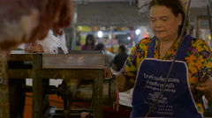 A Thai woman grinds fresh meat in a traditional market in Asia [139677923] | 写真素材・ストックフォトのアフロ