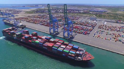 AERIAL: Fully loaded container ship docked at freight port terminal