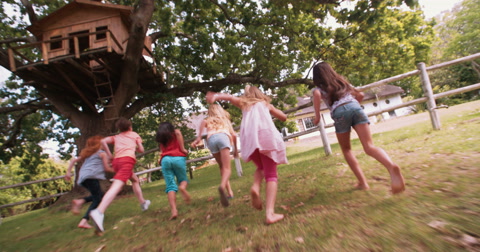 Children playing on a rustic wooden fence in a park