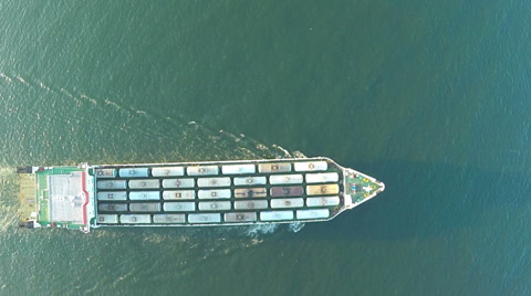 AERIAL, trade ship in the sea. Flying above ship in the ocean, waves in front.