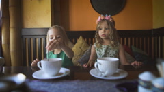 Two cute little girls are having tea in a cafe [46655564] | 写真素材・ストックフォトのアフロ