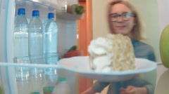 Young woman opens the fridge eating cake very fast and drinks … [46031187] | 写真素材・ストックフォトのアフロ