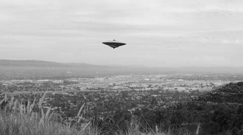 FLYING SAUCER / UFO  HOVERS OVER A VALLEY