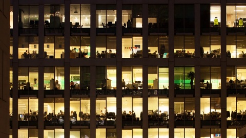 Time-lapse of an office at night panning down to show workers leaving