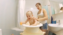 Cute active baby boy bathing with young smiling mother [45081545] | 写真素材・ストックフォトのアフロ