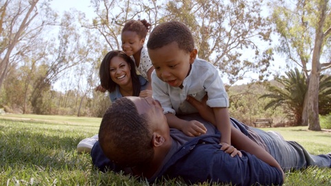 Parents playing with their young kids in the park, low angle