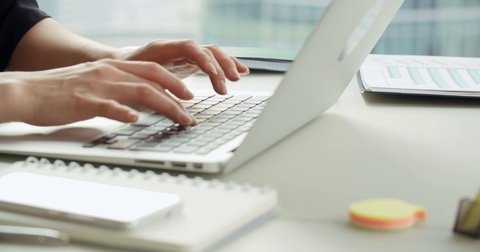 close-up of Asian business girl in a modern office, working using laptop