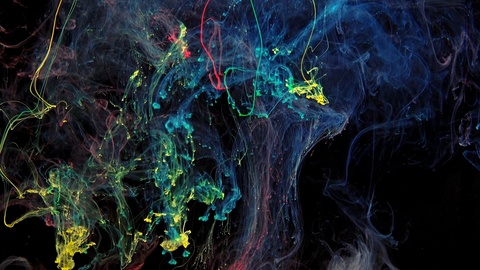 Colorful rainbow paint drops from mixing in water. Ink swirling underwater.