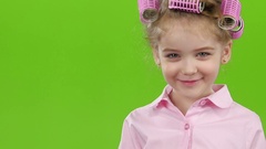 Little girl in hair curlers shows tongue on camera. Green screen. … [44089520] | 写真素材・ストックフォトのアフロ