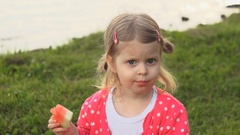 Little cute baby girl eat red watermelon sits on the green … [43574461] | 写真素材・ストックフォトのアフロ