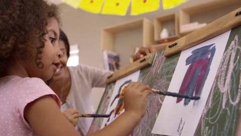 Teacher At Montessori School Helping Children in Art Class