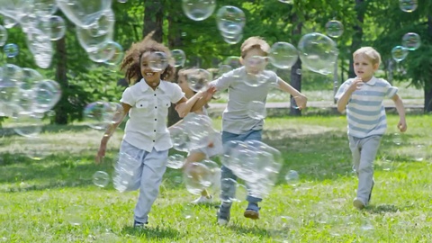 Funny Kids Running and Playing with Bubbles at Sunny Day