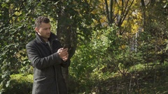 Young guy in coat searches a signal of network on his smartphone … [138197456] | 写真素材・ストックフォトのアフロ