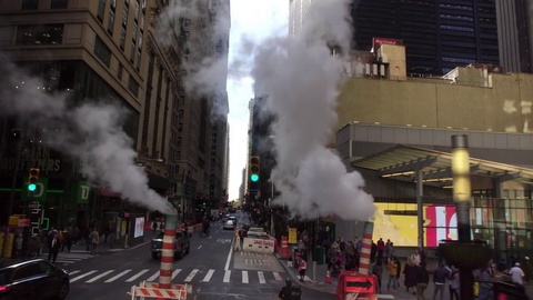 Drone shot of busy NYC New York City Manhattan street with steam during the day