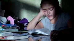 schoolgirl learns lessons, homework. reading a book, she learns … [137955332] | 写真素材・ストックフォトのアフロ