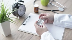 Female doctor holding unlabeled bottle of various pills and … [132716377] | 写真素材・ストックフォトのアフロ