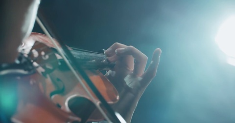 Asian violinist soloist male performing at a concert of classical music, close