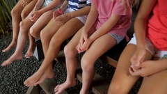 A group of young girls laps, legs and feet sitting next to … [136389777] | 写真素材・ストックフォトのアフロ