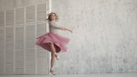 ballerina is spinning on her toe in a pink dress. young girl dances classical