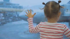 Little child girl looks out of window on airplane, rear wiew. [136203109] | 写真素材・ストックフォトのアフロ