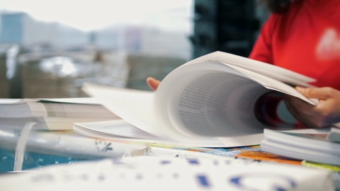 Hands of female worker in typography turning printed pages