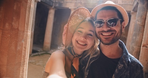 Young couple having fun taking selfies at Greek classical monument