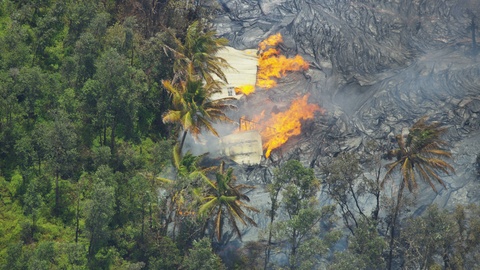 Aerial of moving volcanic magma destroying buildings Kilauea