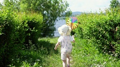 A little cute girl playing with a colorful pinwheel in the … [131284066] | 写真素材・ストックフォトのアフロ
