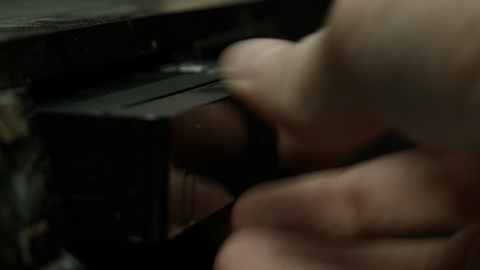 VHS tape being placed into dusty tape deck